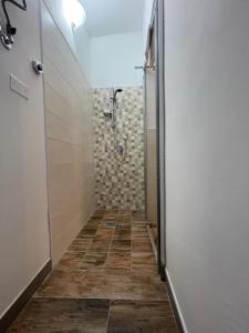a bathroom with a shower and a tile floor at L'Acero di STALL in Viterbo