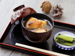 a bowl of food on a black plate with chopsticks at New Yokote in Yamanouchi