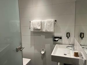 a bathroom with a sink and a toilet and towels at Hotel Römischer Kaiser in Trier