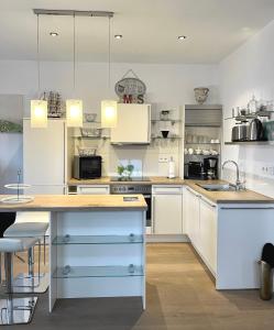uma cozinha com armários brancos e uma ilha azul em Palazzo Exclusiv Appartment em Tegernsee