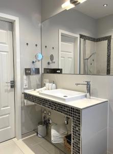 a white bathroom with a sink and a mirror at Palazzo Exclusiv Appartment in Tegernsee