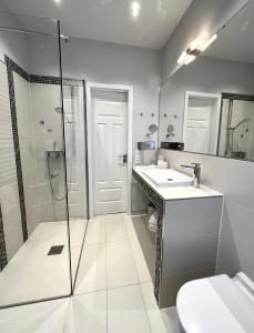 泰根塞的住宿－Palazzo Exclusiv Appartment，一间带两个盥洗盆、淋浴和卫生间的浴室