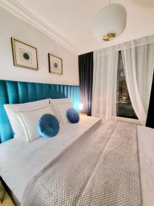 a bedroom with a large white bed with blue pillows at RentPlanet - Apartamenty Chlebova II in Gdańsk