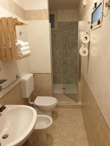 a bathroom with a toilet and a sink and a shower at Appartamento La Carambola 110mq in Maglie +13 photos