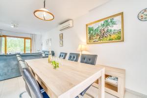 een eetkamer met een houten tafel en stoelen bij Ideal Property Mallorca - Sirenas in Playa de Muro