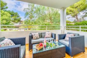 un patio con 2 sillas de mimbre y una mesa en Ideal Property Mallorca - Sirenas en Playa de Muro
