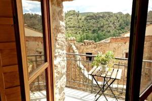 a room with a view of a balcony with a table at La Casirria in Olba