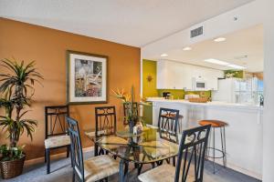a kitchen and dining room with a glass table and chairs at SeaCrest 706 condo in Fort Walton Beach