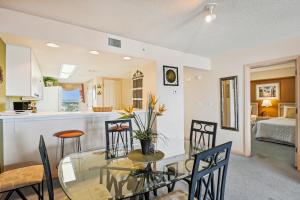 a dining room and kitchen with a glass table and chairs at SeaCrest 706 condo in Fort Walton Beach