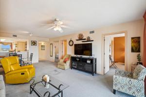 a living room with a yellow chair and a couch at SeaCrest 706 condo in Fort Walton Beach