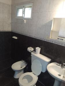a bathroom with a toilet and a sink at Cabañas Nicasio in Merlo