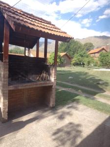 a outdoor grill with a roof on a yard at Cabañas Nicasio in Merlo +4 photos