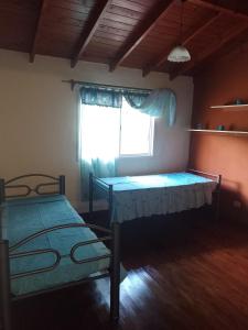 two beds in a room with a window at Cabañas Nicasio in Merlo