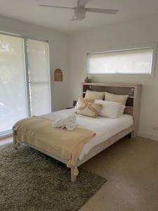 a bedroom with a large bed with white pillows at Drift - Luxury, location and ocean views in Wye River