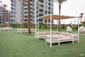 a group of white couches and umbrellas on a lawn at a chilled place in Dubai