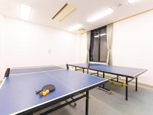 dos mesas de ping pong en una habitación vacía con en Tabist Yabuki Golf Club, en Yabuki