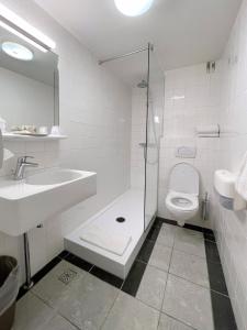 een witte badkamer met een wastafel en een toilet bij Hotel Residence Le Coin in Amsterdam +37 foto's