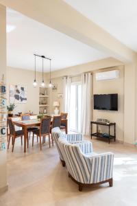 a dining room and living room with a table and chairs at Amazing Modern Apartment with Sea View in Athens