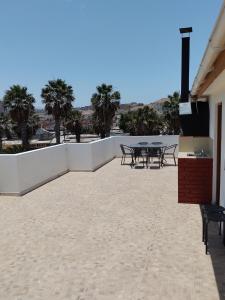 a patio with tables and chairs and palm trees at DepartoCasa1 Premium in Arica