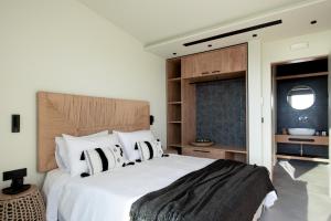 a bedroom with a large white bed with a wooden headboard at Gaia and Thalatta Villas in Évyiros