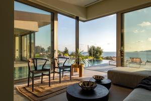 a living room with large windows and a view of the ocean at EGO Villas Lefkada in Évyiros