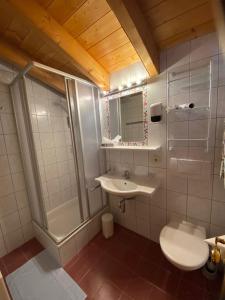 a bathroom with a sink and a shower and a toilet at Landhaus Paradies Samnaun Spiss in Spiss