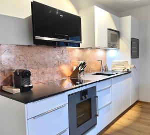 a kitchen with a counter with a sink and a microwave at Palais Karl-Theodor in Rottach-Egern