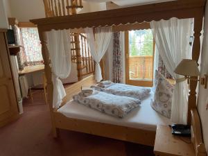 1 dormitorio con cama con dosel y ventana en Landhaus Paradies Samnaun Spiss, en Spiss