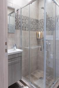 La salle de bains est pourvue d'une douche et d'un lavabo. dans l'établissement Amazing Modern Apartment with Sea View, à Athènes