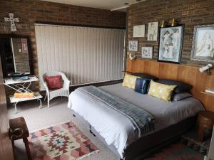 ein Schlafzimmer mit einem Bett in einem Zimmer mit Ziegelwänden in der Unterkunft Sonvanger in Lambertʼs Bay