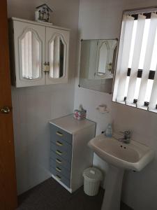 W łazience znajduje się umywalka, lustro i biała umywalka. w obiekcie Sonvanger w mieście Lambertʼs Bay