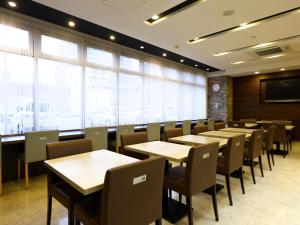 une salle de conférence avec des tables, des chaises et une télévision dans l'établissement Dormy Inn Takasaki, à Takasaki