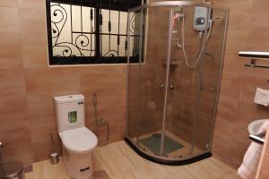a bathroom with a shower and a toilet at Eric Wilkins Apartments in Kampala
