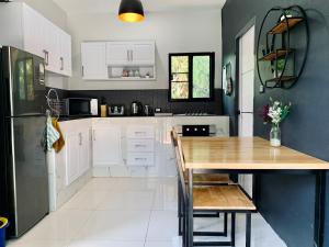 a kitchen with white cabinets and a wooden table at Bonnie Baan Private Pool Villa, Mae Rim in Mae Rim