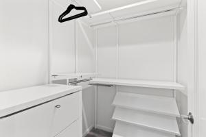 una cocina blanca con armarios blancos y estantería en @ Marbella Lane - Hidden Gem in Pacifica! en Pacifica
