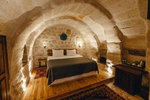 ギョレメにあるHanzade Cappadociaの石壁のベッドルーム1室