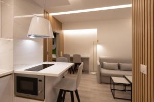 a kitchen and living room with a table and chairs at LUX&EASY Acropolis Suites in Athens