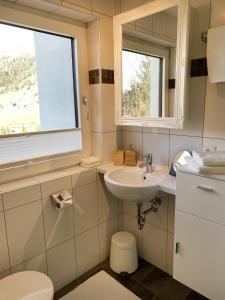 a bathroom with a sink and a toilet and a window at Wohnung Steixner in Westendorf
