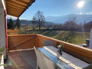 a balcony with a table and chairs and a view of a field at Wohnung Steixner in Westendorf