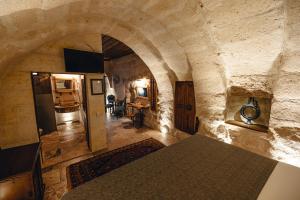 Pokój z kamienną ścianą i stołem w pokoju w obiekcie Hanzade Cappadocia w Göreme