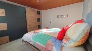 a bedroom with a bed with colorful sheets and pillows at Fewo Am Tiefen Weg in Karlstadt