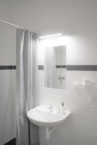 a white bathroom with a sink and a mirror at GLOBE Hostel Prague ADULTS ONLY in Prague