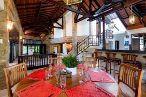 a dining room with a wooden table with red napkins at Villa Frangipani Seminyak in Seminyak