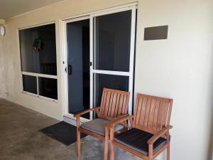 un par de sillas sentadas al lado de una puerta en Beachside & Jetty View Apartment 4 - First Mate Apt limited sea view, en Streaky Bay