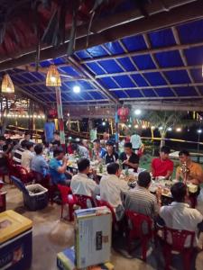 三岐的住宿－Canh Tien Homestay Tam Thanh Beach，一群坐在餐厅桌子上的人