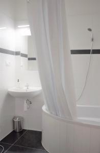 a white bathroom with a sink and a shower at GLOBE Hostel Prague ADULTS ONLY in Prague