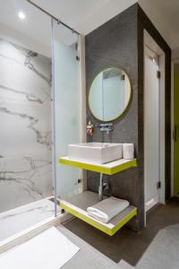 La salle de bains est pourvue d'un lavabo et d'un miroir. dans l'établissement Le ROI Express Paharganj, à New Delhi