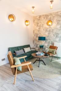 a living room with a green couch and a table at Villa d'Eaux in Villers-sur-Mer