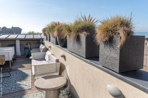 a balcony with potted plants on a building at Villa d'Eaux in Villers-sur-Mer