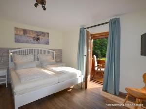 um quarto com uma cama e uma porta de vidro deslizante em Appartement Petra em Kössen